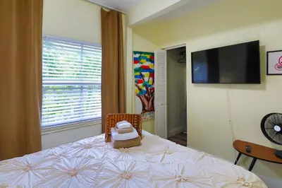 a bedroom with a bed with a television on the wall at Artful 3BR Oasis in Little Haiti, Miami in Miami