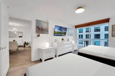 a white bedroom with two beds and a window at Impressive Unit in the heart of Brickell W Parking in Miami