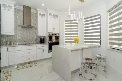 a white kitchen with white cabinets and a counter at The tropical paradise villa in Miami