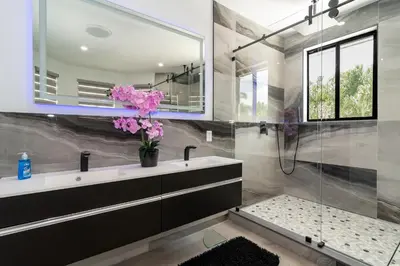 a bathroom with a sink and a glass shower at The tropical paradise villa in Miami