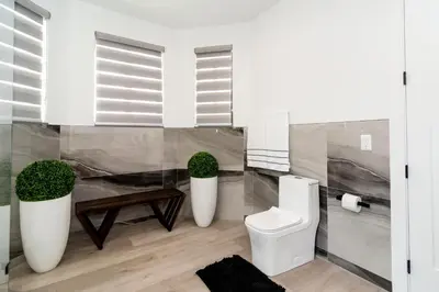 a bathroom with a toilet and two potted plants at The tropical paradise villa in Miami