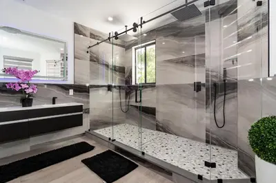 a bathroom with a shower with a glass door at The tropical paradise villa in Miami