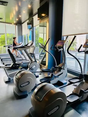 a woman sitting on a treadmill in a gym at Beachfront hotel room to relax and unwind 09B in Hallandale Beach