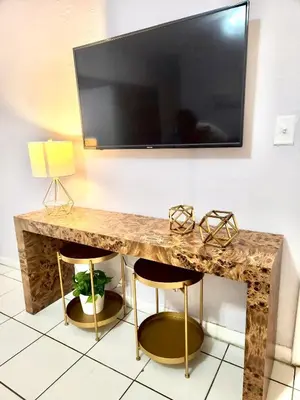 a table with a television on a wall with two stools at Coral Gables / Coconut Grove area FREE parking in Miami