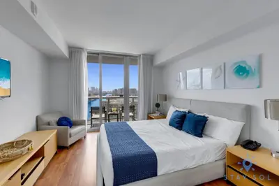 a bedroom with a bed and a living room at Apartment with Balcony, Gym, Pool in Hallandale Beach