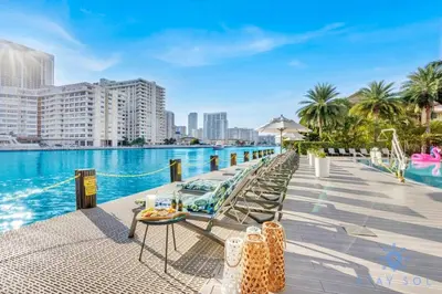 a pool at a hotel with chairs and a table at Pool Apartment with Balcony, Near Beach in Hallandale Beach