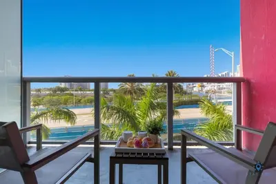 a balcony with two chairs and a table with fruit at Modern Resort with Balcony - Near Beach - Pool in Hallandale Beach