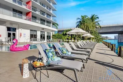 a row of chaise lounge chairs next to a pool at Modern Resort with Balcony - Near Beach - Pool in Hallandale Beach