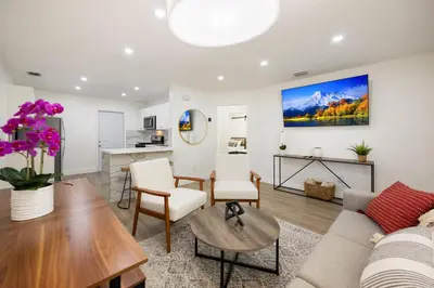 a living room with a couch and a table at 3 BR Smart home, close to airport, Fast WiFi, Patio, Grill & Free private parking in Miami