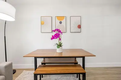 a table with a vase of flowers on it at 3 BR Smart home, close to airport, Fast WiFi, Patio, Grill & Free private parking in Miami