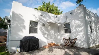 a white house with two chairs in front of it at Stylish Studio Near Wynwood & Design District in Miami