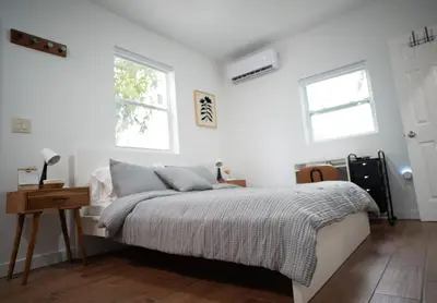 a white bedroom with a bed and two windows at Stylish Studio Near Wynwood & Design District in Miami