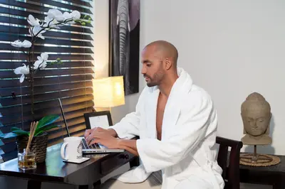 a man sitting at a desk using a laptop computer at Vive Zen Master Suite for 4 Guests in Miami