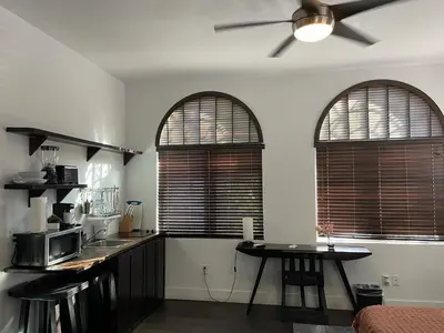 a kitchen with two windows and a table with a ceiling fan at Vive Zen Master Suite for 4 Guests in Miami
