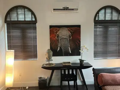 a room with a table with a painting of an elephant at Vive Zen 2 Queen Beds in Miami