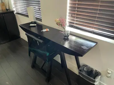 a black desk with a vase of flowers on it at Vive Zen Queen Room in Miami