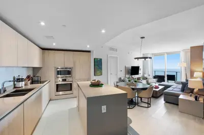 a kitchen and living room with a couch and a table at Picturesque Beachfront Condo - LOVELY 2BD and 2BA APT WITH DIRECT OCEAN VIEW in Hollywood