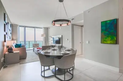 a dining room and living room with a table and chairs at Iconic Ocean View - in this Stunning Condo in Hollywood
