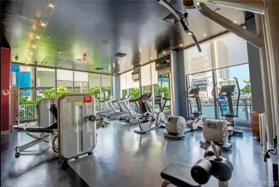 a gym with a lot of treadmills and machines at BeachWalk Studio Apt with Beach Service 03B in Hallandale Beach
