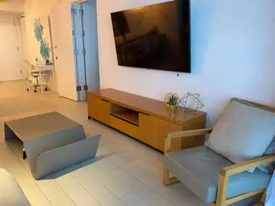a living room with a couch and a tv on the wall at Dream Beach Apt 1BR Kitchen & Pool Access 06A in Hallandale Beach