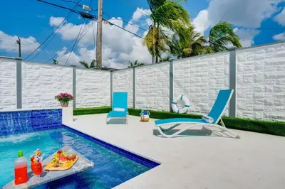 a swimming pool with a table and chairs next to a pool at Hollywood Home w Pool Jacuzzi BBQ and Pool Table in Hollywood
