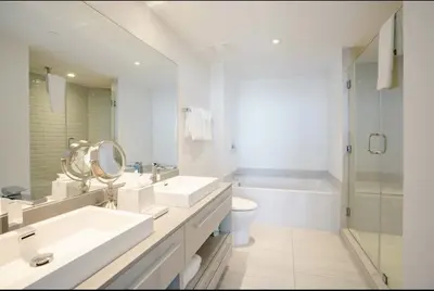 a white bathroom with two sinks and a toilet at Lux apartment Hyde Beach House in Hollywood