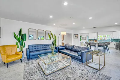 a living room with blue couches and a kitchen at 180 of Waterfront Heated Pool Walk To Beach Paradise Point Key RESIDENCES in Fort Lauderdale