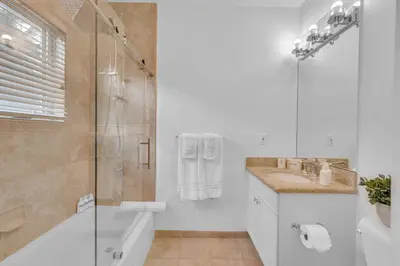 a bathroom with a shower and a sink and a tub at Steps from the Beach Heated Pool Sun Key Game room RESlDENCES in Fort Lauderdale