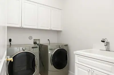 a kitchen with a washing machine and a sink at Steps from the Beach Heated Pool Sun Key Game room RESlDENCES in Fort Lauderdale