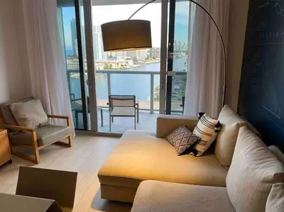 a living room with a couch and a large window at Miami Beach 1 Bedroom w Pool 1109A in Hallandale Beach