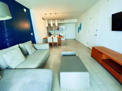 a living room with a couch and a table at Modern Beach Apartment, 3 Beds, Views & Full Kitchen in Hallandale Beach