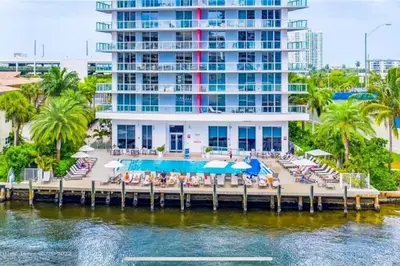 a resort with a dock with chairs and a pool at Modern Beach Apartment, 3 Beds, Views & Full Kitchen in Hallandale Beach