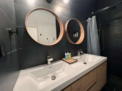 a bathroom with a white sink and two mirrors at Amazing 3-bedroom modern home in Coral Gables area in Miami