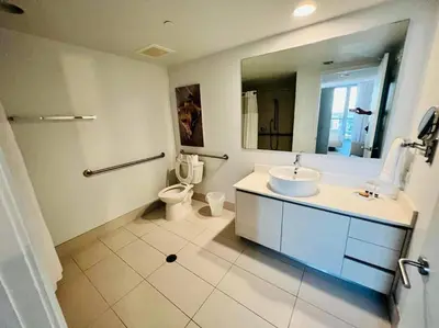 a bathroom with a sink and a toilet and a mirror at Miami Beach Luxury Apt, Ocean Views, Full Kitchen -A in Hallandale Beach