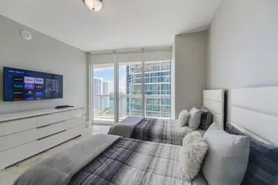 a bedroom with two beds and a flat screen tv at Wonderful 2 BR Condo Icon Brickell With Pool in Miami