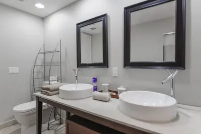 a bathroom with two sinks and a toilet and mirrors at Wonderful 2 BR Condo Icon Brickell With Pool in Miami