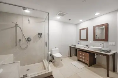a bathroom with a shower and two sinks and a toilet at Wonderful 2 BR Condo Icon Brickell With Pool in Miami