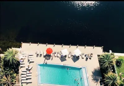 an overhead view of a swimming pool with chairs and a swimming pool at Just Minutes from the Beach, 2 Full Bed Studio in Hallandale Beach