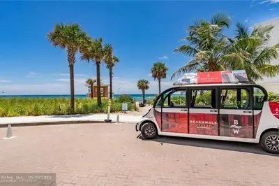 a small car parked next to a beach with palm trees at Just Minutes from the Beach, 2 Full Bed Studio in Hallandale Beach
