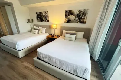 a hotel room with two beds and a window at Your Coastal Studio, 2 Full Beds & Ocean Vibes in Hallandale Beach