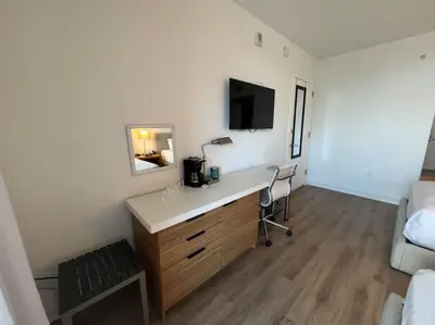 a room with a desk with a television and a bed at Your Coastal Studio, 2 Full Beds & Ocean Vibes in Hallandale Beach