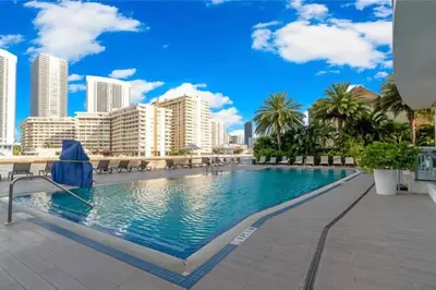 a swimming pool with a city skyline in the background at Studio BeachWalk, Ocean Breeze & 2 Full Beds in Hallandale Beach