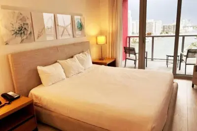 a hotel room with a bed and a balcony at Luxe Beachfront Living - Premium Comfort -A in Hallandale Beach