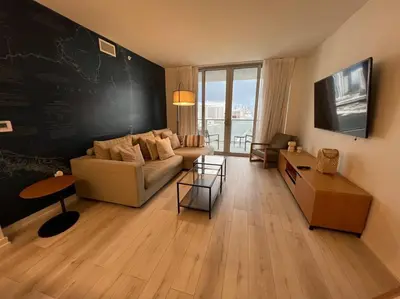 a living room with a couch and a chalkboard wall at Luxe Beachfront Living - Premium Comfort -A in Hallandale Beach
