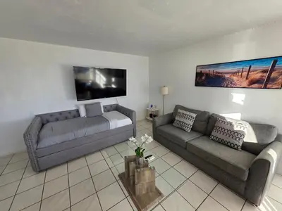 a living room with two couches and a tv at Bayfront Apartment Breathtaking Views- one bedroom w balcony- living room -Free Parking in Miami Beach