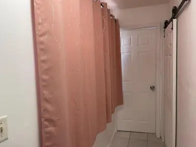 a bathroom with a pink shower curtain and a door at Best Value inside City Miami, Near Airport, Beach, Center & Metro in Miami